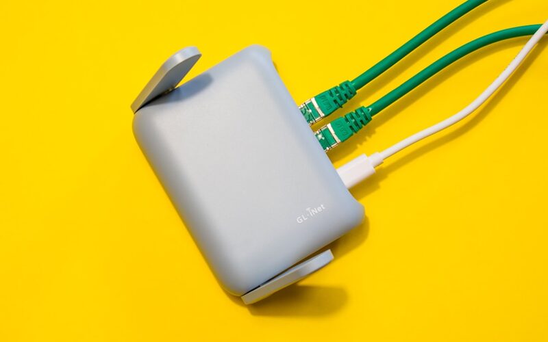 Router mit bunten Netzwerkkabeln – Pi-hole sitzt als DNS-Server zwischen Router und Endgeräten